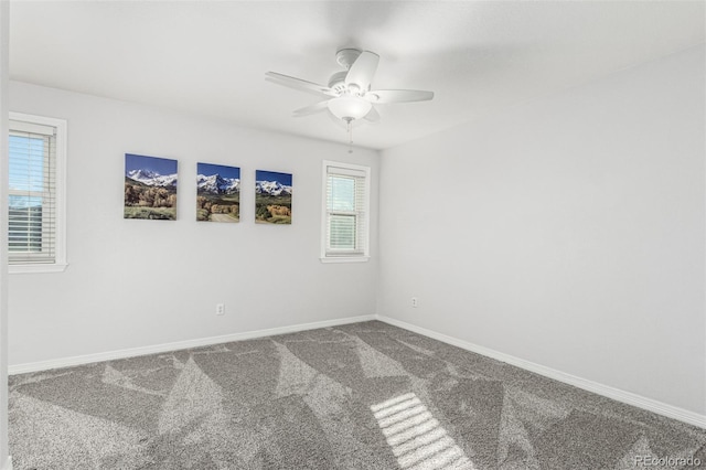 carpeted spare room featuring ceiling fan