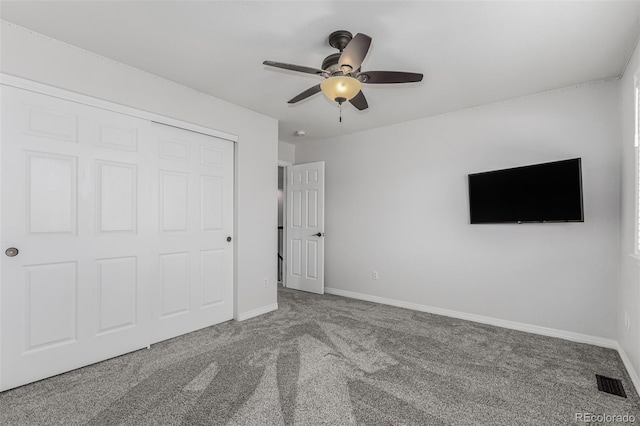 unfurnished bedroom with carpet floors, ceiling fan, and a closet