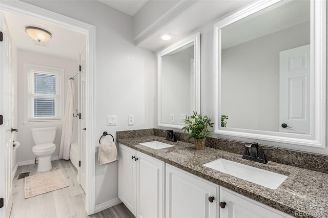 full bathroom with vanity, toilet, hardwood / wood-style floors, and shower / bath combo