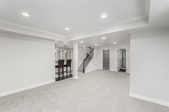 basement featuring light carpet and ornamental molding