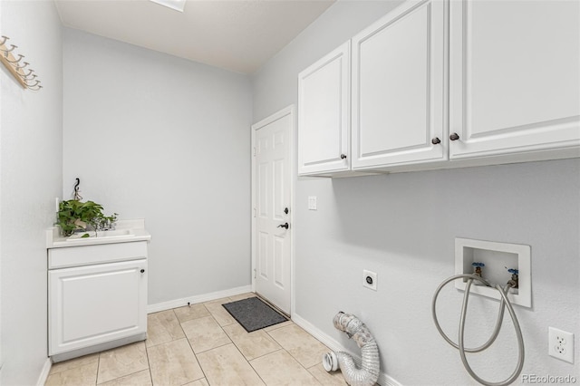 clothes washing area featuring cabinets, hookup for a washing machine, hookup for an electric dryer, and light tile patterned floors