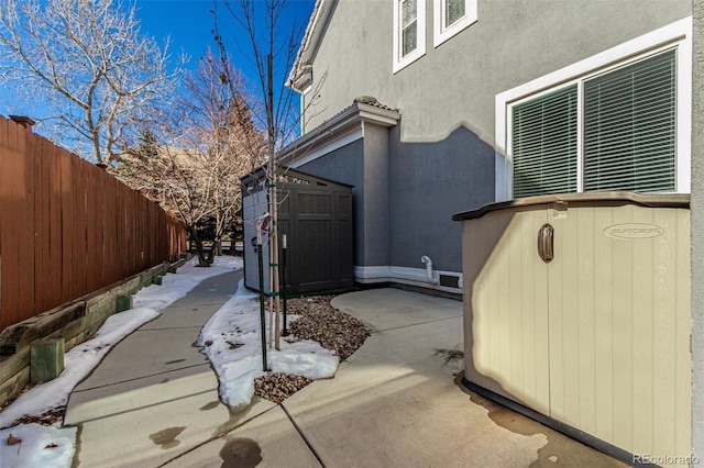 view of property exterior with a storage shed and a patio