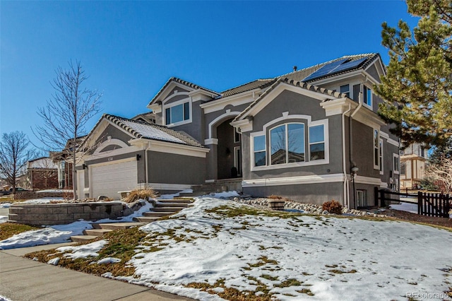 view of front of home with stucco siding, a tiled roof, a garage, and fence