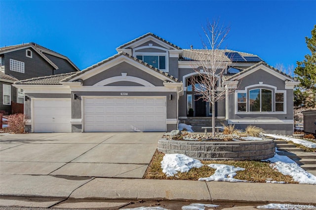 view of front of home with stucco siding, concrete driveway, an attached garage, and a tile roof