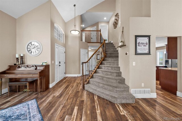603 E 2nd Ave, Castle Rock, CO 80108 - foyer entrance with wood finished floors, stairway, and high vaulted ceiling