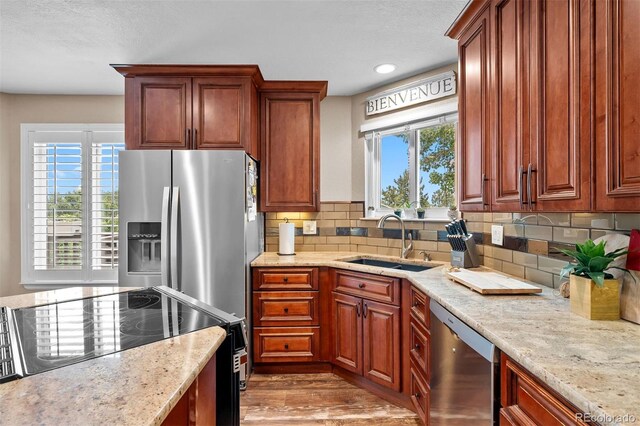 603 E 2nd Ave, Castle Rock, CO 80108 - kitchen featuring appliances with stainless steel finishes, healthy amount of natural light, decorative backsplash, wood finished floors, and recessed lighting