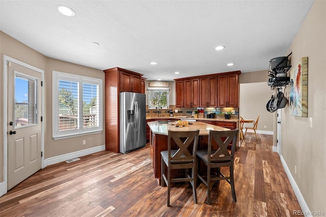 603 E 2nd Ave, Castle Rock, CO 80108 - kitchen featuring stainless steel fridge with ice dispenser, dark wood-type flooring, backsplash, a center island, and recessed lighting