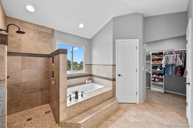 603 E 2nd Ave, Castle Rock, CO 80108 - bathroom featuring a garden tub, a tile shower, a spacious closet, vaulted ceiling, and tile patterned floors