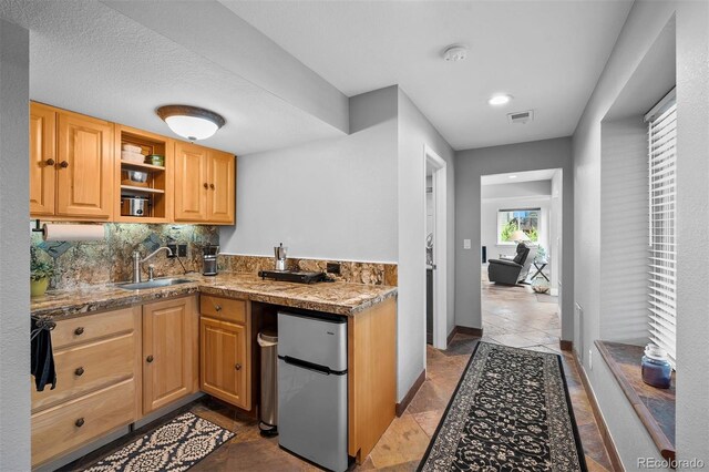 603 E 2nd Ave, Castle Rock, CO 80108 - kitchen featuring freestanding refrigerator, tasteful backsplash, open shelves, tile counters, and light brown cabinets
