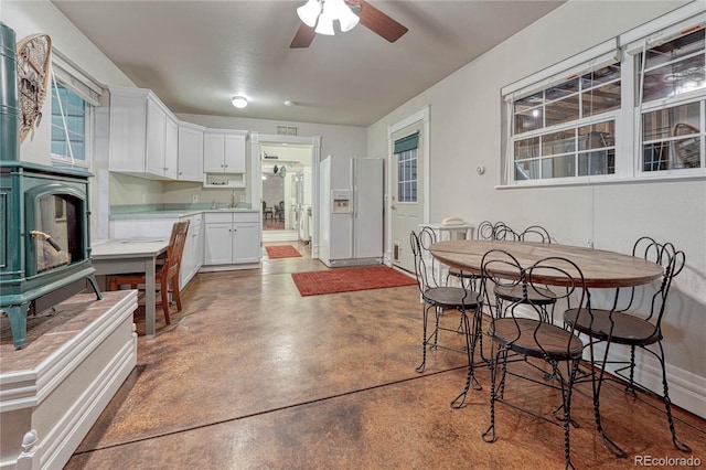 kitchen with white refrigerator with ice dispenser, ceiling fan, sink, and white cabinetry