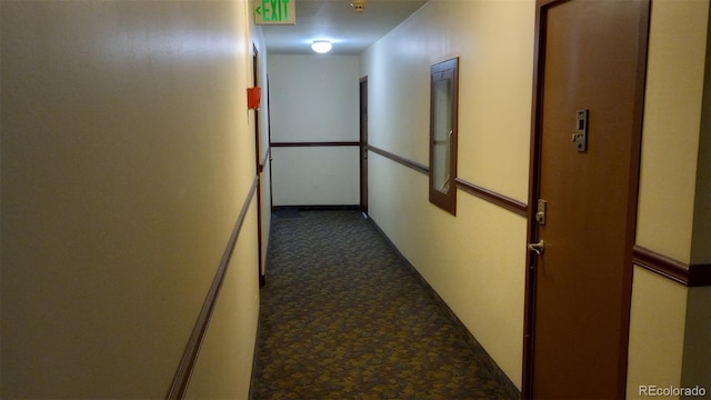 hallway with dark colored carpet