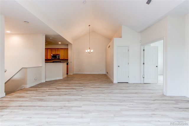 unfurnished room featuring a notable chandelier, light wood-style flooring, baseboards, and vaulted ceiling