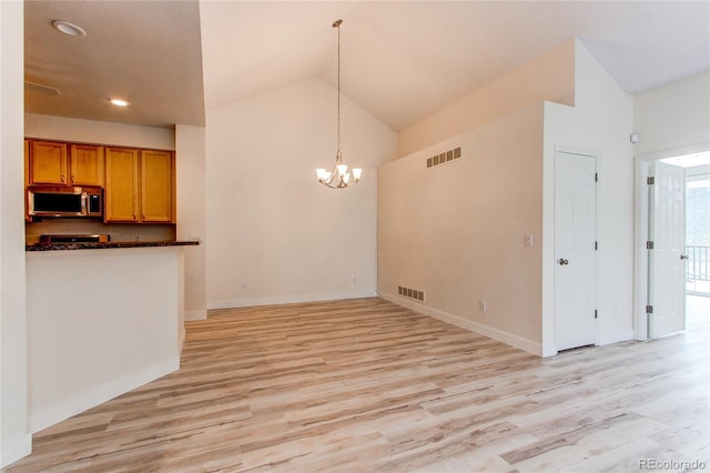 unfurnished dining area with visible vents, light wood finished floors, an inviting chandelier, and vaulted ceiling