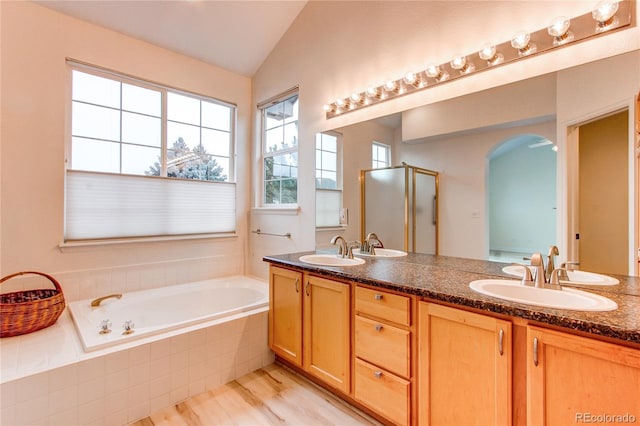 bathroom with lofted ceiling, double vanity, a stall shower, a sink, and a bath