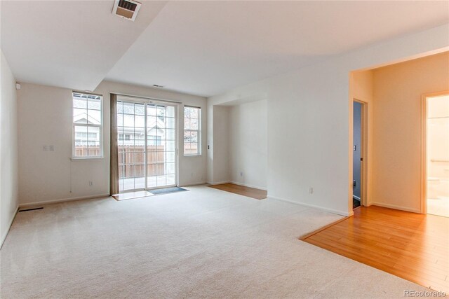 carpeted empty room with visible vents and baseboards