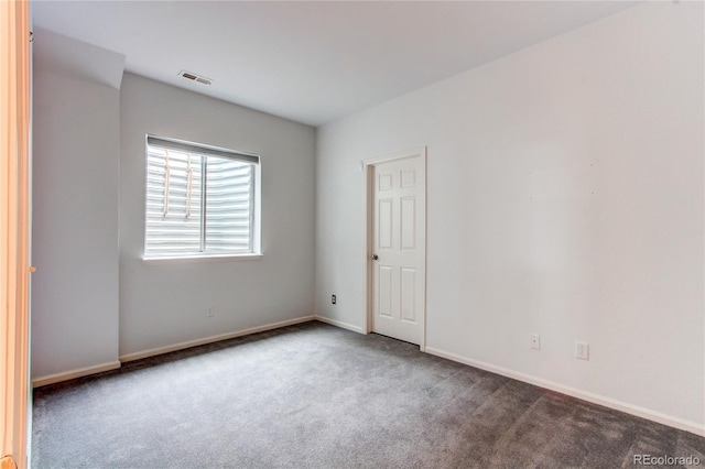 unfurnished room with carpet flooring, baseboards, and visible vents