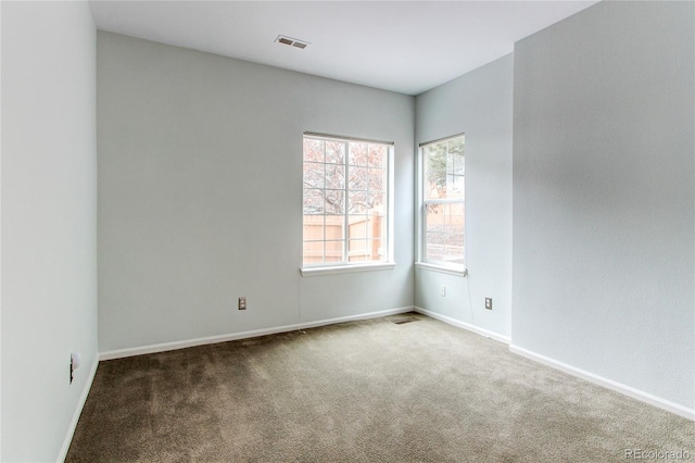 spare room featuring visible vents, baseboards, and carpet floors