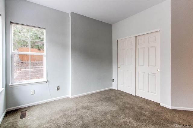 unfurnished bedroom with a closet, baseboards, visible vents, and carpet floors