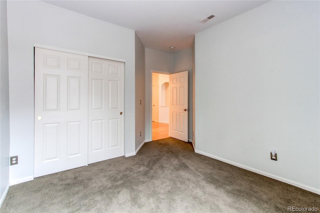 unfurnished bedroom with a closet, visible vents, baseboards, and carpet