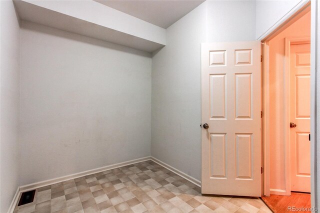 interior space with baseboards and light floors