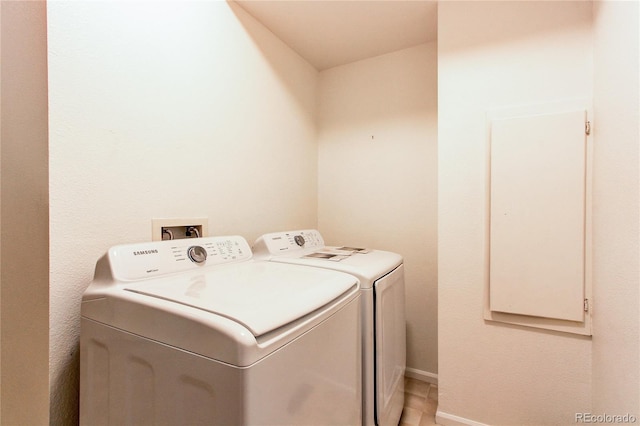 washroom with laundry area, separate washer and dryer, and baseboards