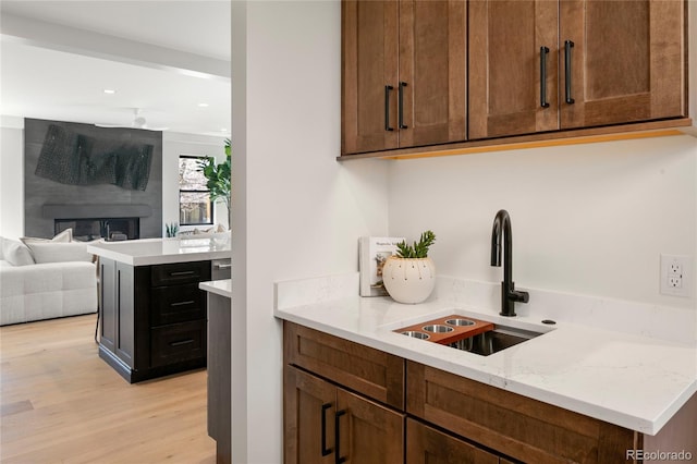 1195 S Milwaukee St, Denver, CO 80210 - kitchen with a sink, light wood finished floors, open floor plan, recessed lighting, and light stone counters