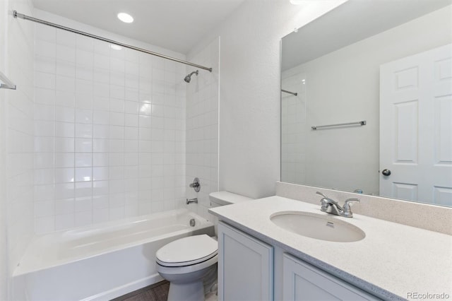 full bathroom with vanity, tiled shower / bath combo, and toilet