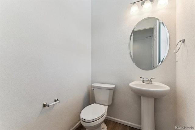 bathroom featuring wood-type flooring and toilet