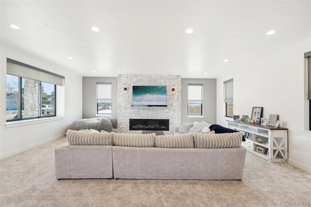 living room featuring light carpet, a fireplace, and a wealth of natural light