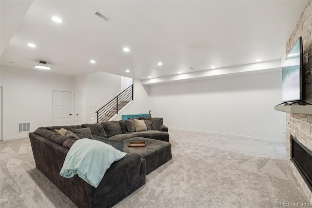 living room featuring light colored carpet and a fireplace