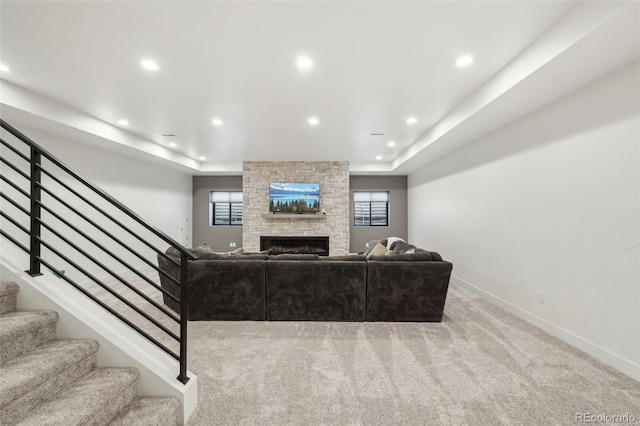 living room with light carpet and a stone fireplace