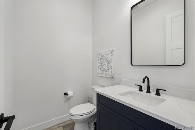 bathroom featuring toilet, hardwood / wood-style flooring, and vanity