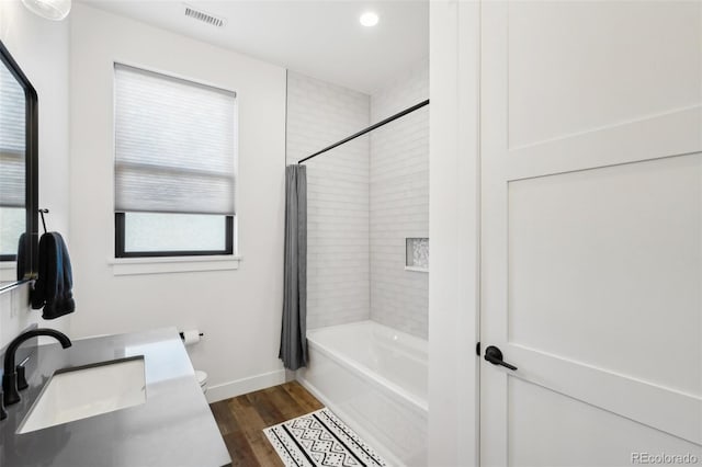 full bathroom with toilet, vanity, wood-type flooring, and shower / tub combo with curtain