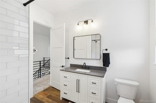 bathroom featuring toilet, hardwood / wood-style floors, and vanity