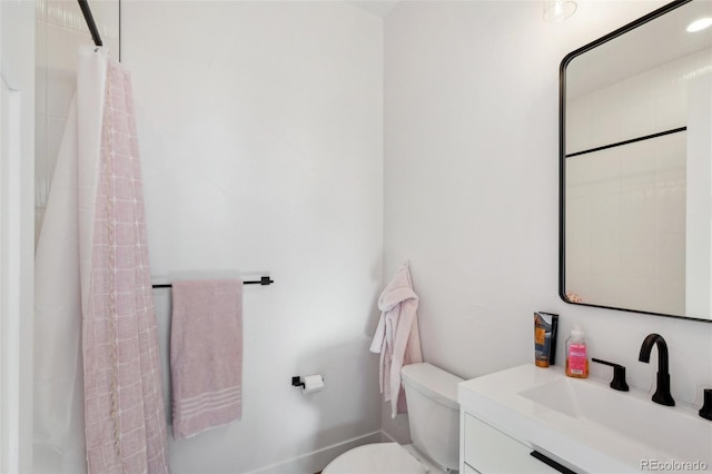 bathroom with toilet, vanity, and a shower with shower curtain