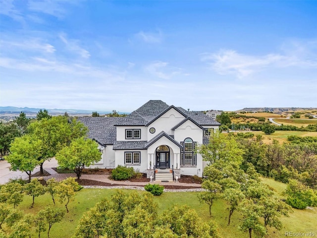 french country style house featuring stucco siding