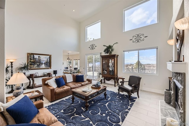 tiled living room featuring a high end fireplace and baseboards