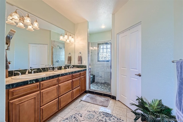 bathroom with a sink, a shower stall, and double vanity