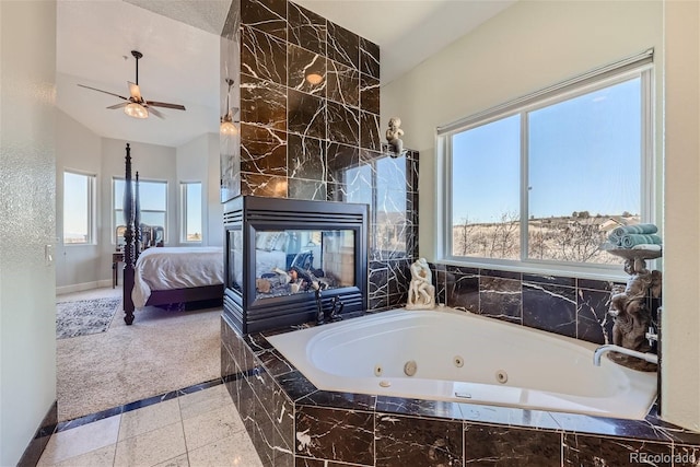 ensuite bathroom with a jetted tub, ensuite bath, a tiled fireplace, and a wealth of natural light