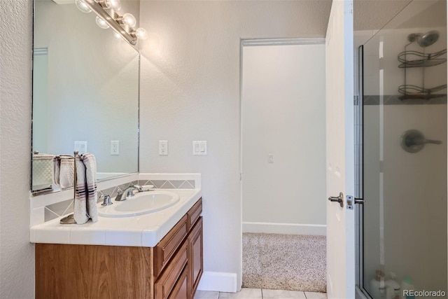 full bath with a stall shower, vanity, and baseboards