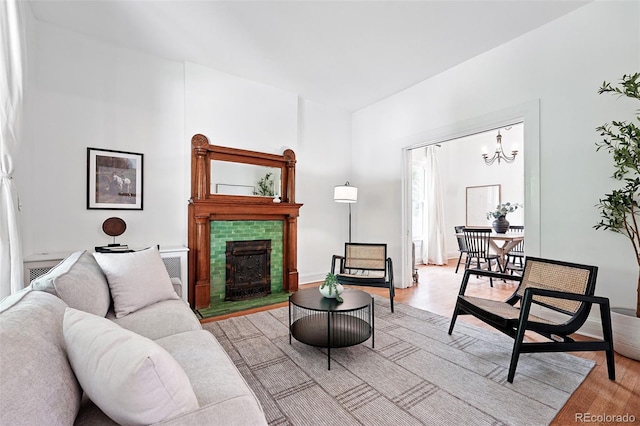 3330 W 30th Ave, Denver, CO 80211 - living room featuring light wood-style flooring, a tiled fireplace, and a chandelier