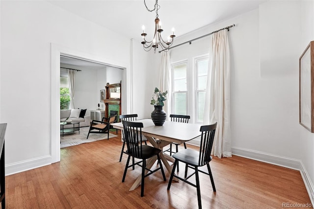 3330 W 30th Ave, Denver, CO 80211 - dining room featuring a chandelier, light wood-style flooring, and baseboards