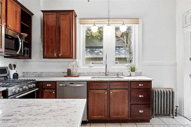3330 W 30th Ave, Denver, CO 80211 - kitchen featuring radiator heating unit, stainless steel appliances, a sink, light stone counters, and light tile patterned flooring