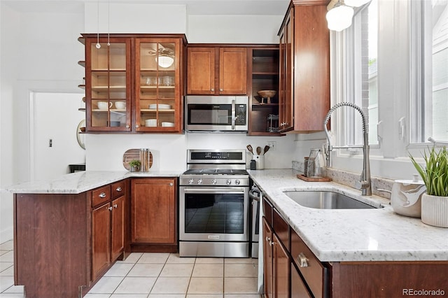3330 W 30th Ave, Denver, CO 80211 - kitchen with appliances with stainless steel finishes, a sink, light tile patterned floors, a peninsula, and healthy amount of natural light