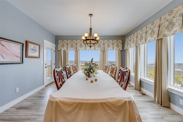 dining room with light hardwood / wood-style flooring and a notable chandelier