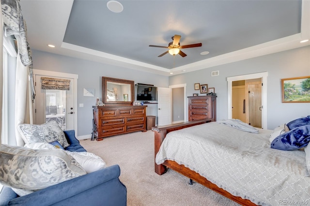 carpeted bedroom featuring ceiling fan and a tray ceiling