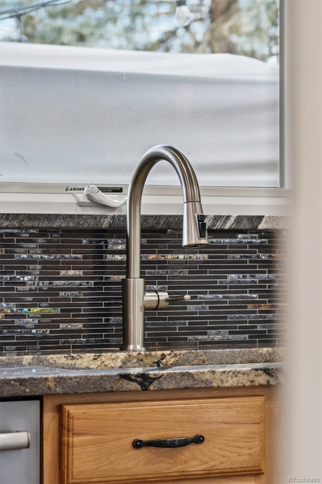 interior details featuring sink and dark stone countertops