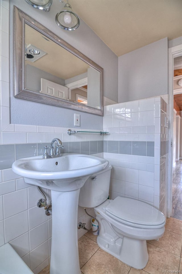 11 Hupp Rd, Bailey, CO 80421 - half bath featuring toilet, a wainscoted wall, tile patterned flooring, and tile walls
