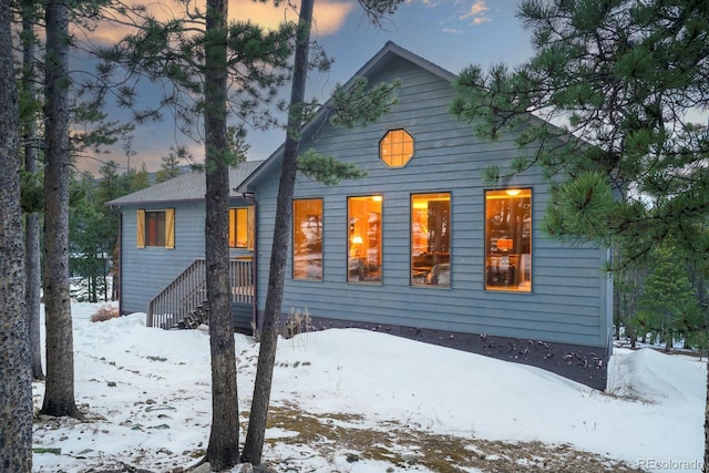 view of snow covered rear of property