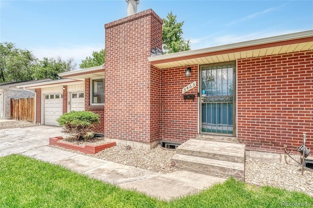 3463 W Bowles Ave, Littleton, CO 80123 - entrance to property featuring an attached garage, a chimney, concrete driveway, and brick siding